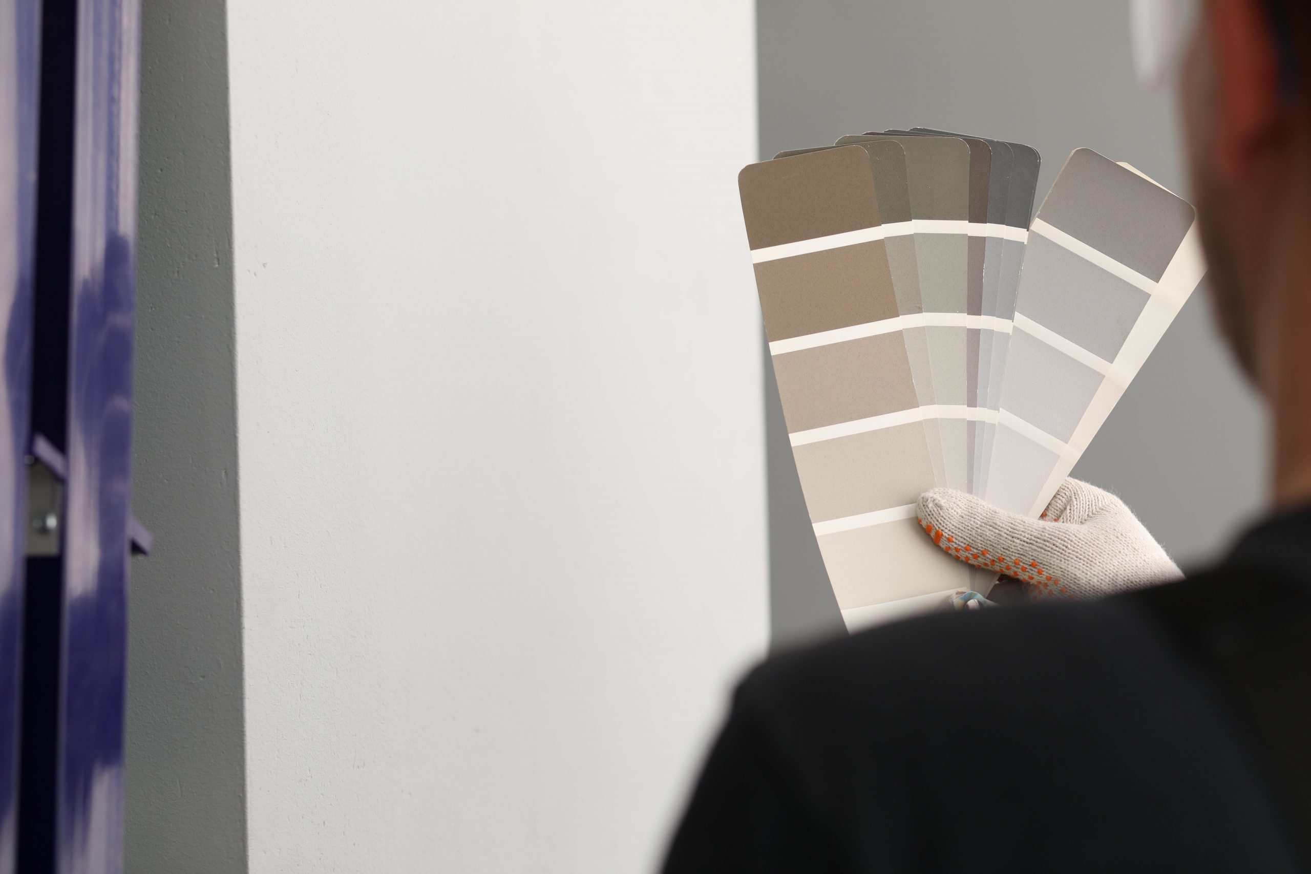blog image of a contractor comparing paint samples for a multifamily renovations job